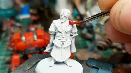 Peinture d'une figurine au pinceau