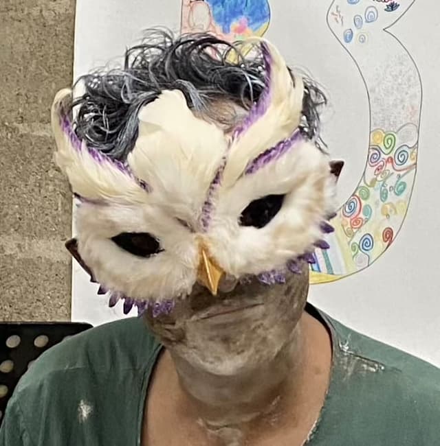 Dilhan Sarica, le conteur, portant un masque de chouette